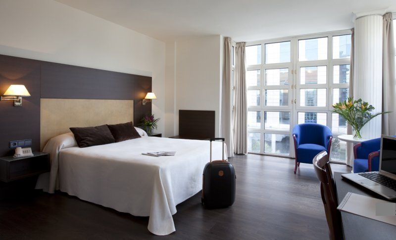 Una habitación de hotel con una cama grande y sillas.
