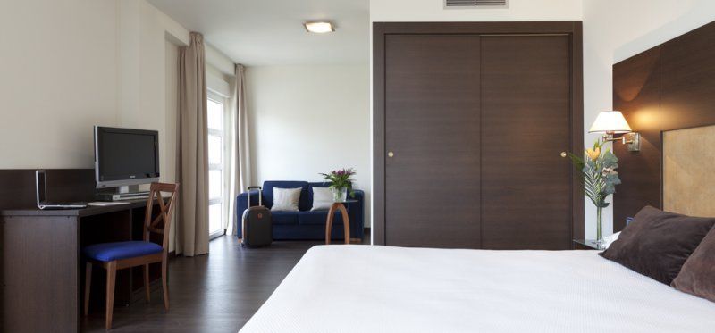 Una habitación de hotel con una cama tamaño king y un sofá.