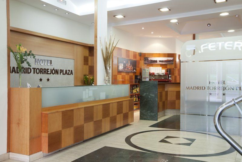 Un vestíbulo de hotel con un cartel que dice Madrid Torrejón Plaza