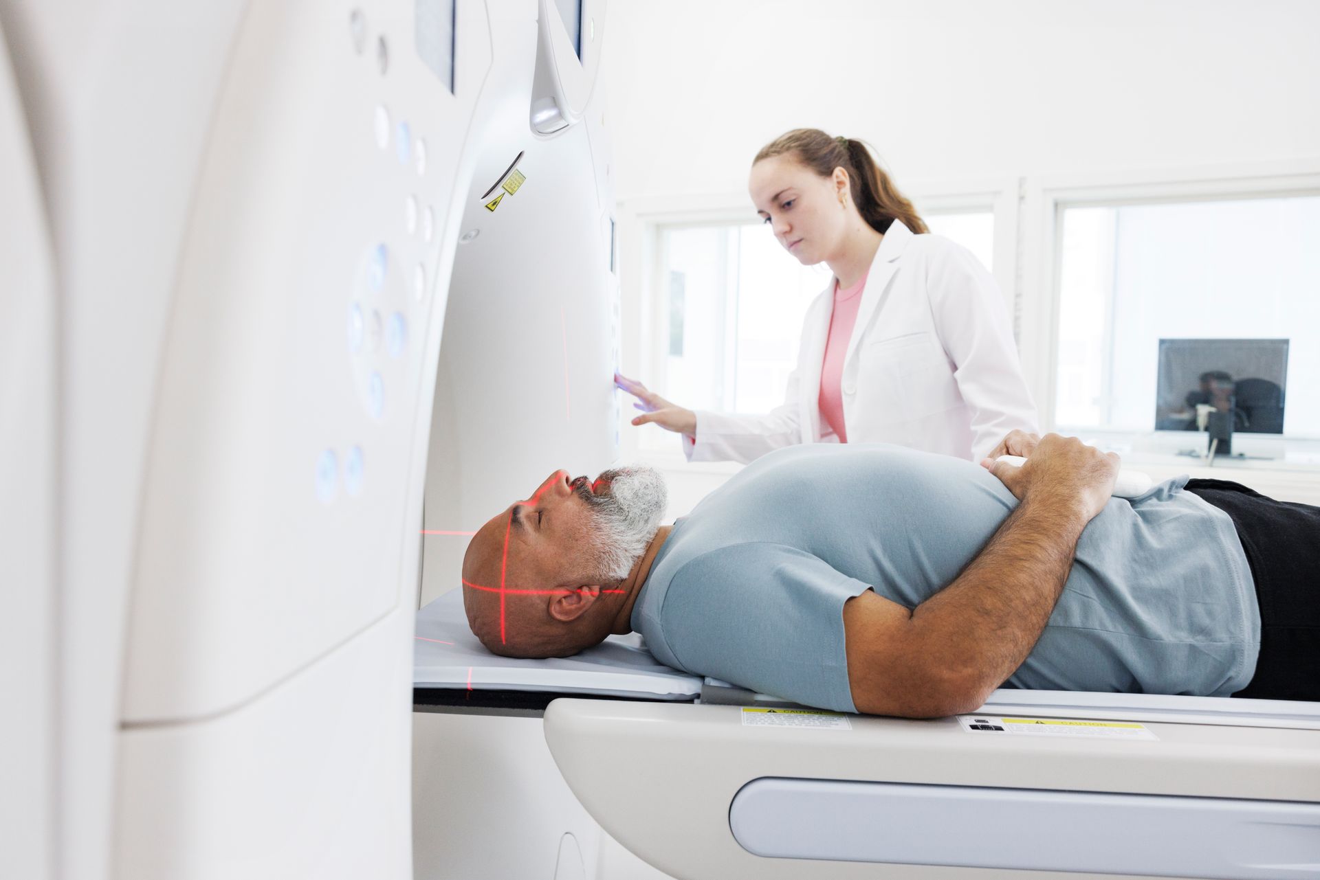 A man is laying on a table getting a ct scan.