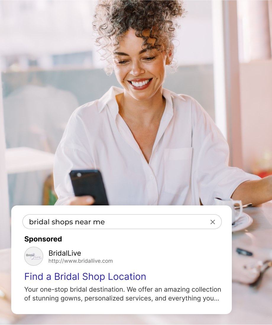 Woman smiling, holding phone, searching for bridal shops. Sponsored ad displayed.