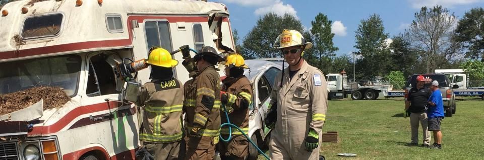 Firefighters examine a damaged RV after an apparent accident.