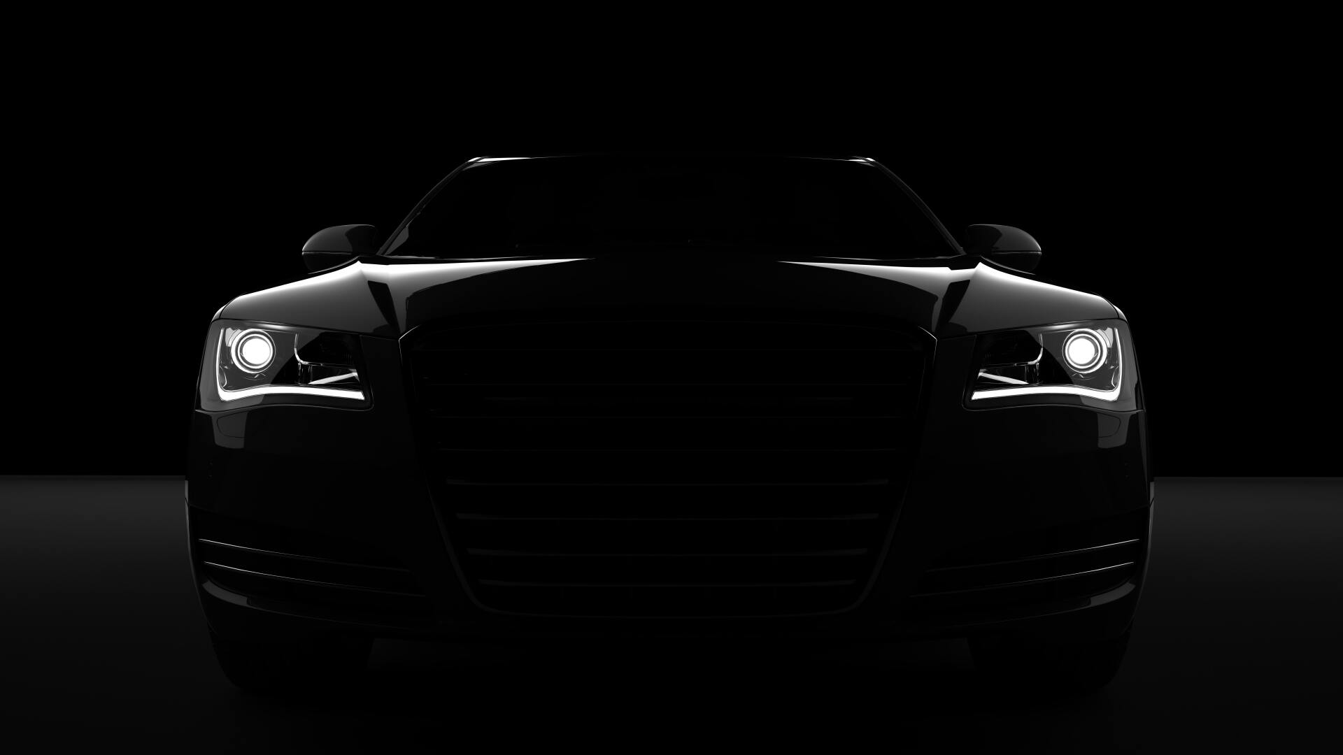Un gros plan des phares d'une voiture dans le noir.
