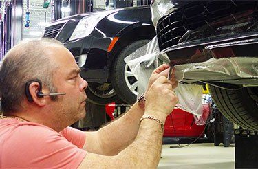 Un homme travaille sur une voiture dans un garage.
