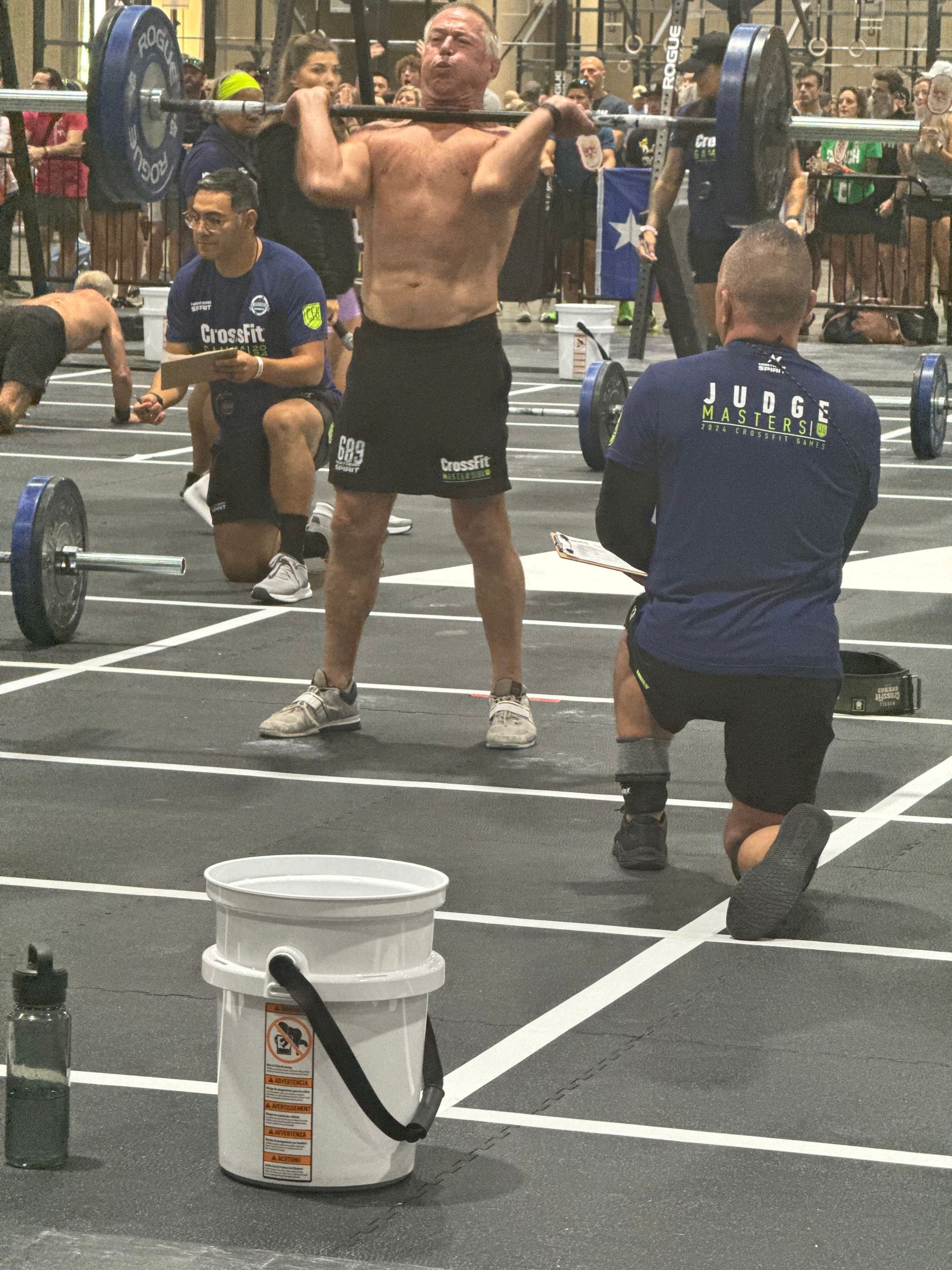 A man squatting with a barbell in a gym