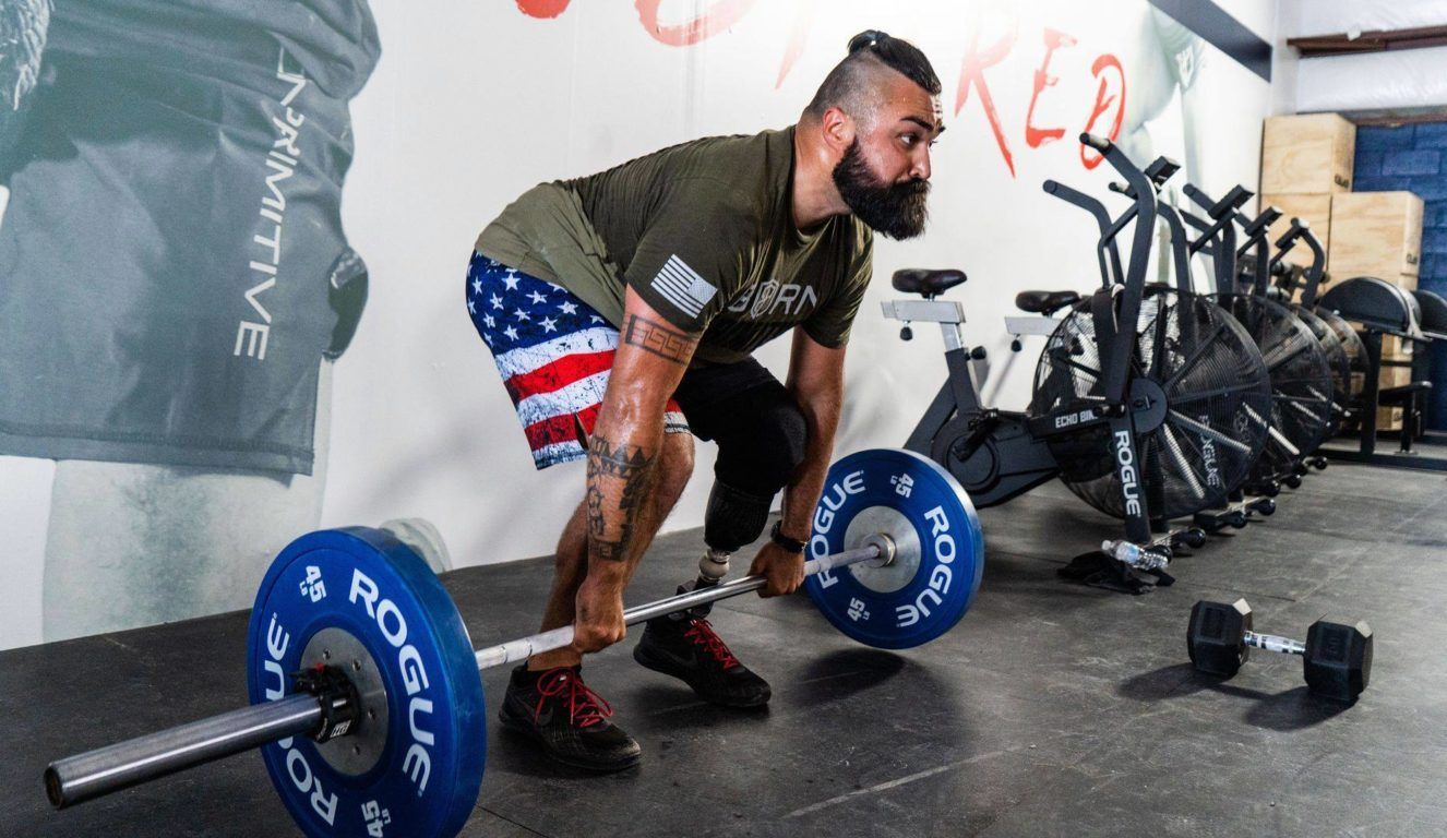 A man is lifting a barbell in a gym.