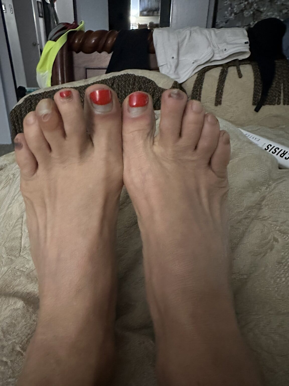 A close up of a person 's feet with red nail polish.