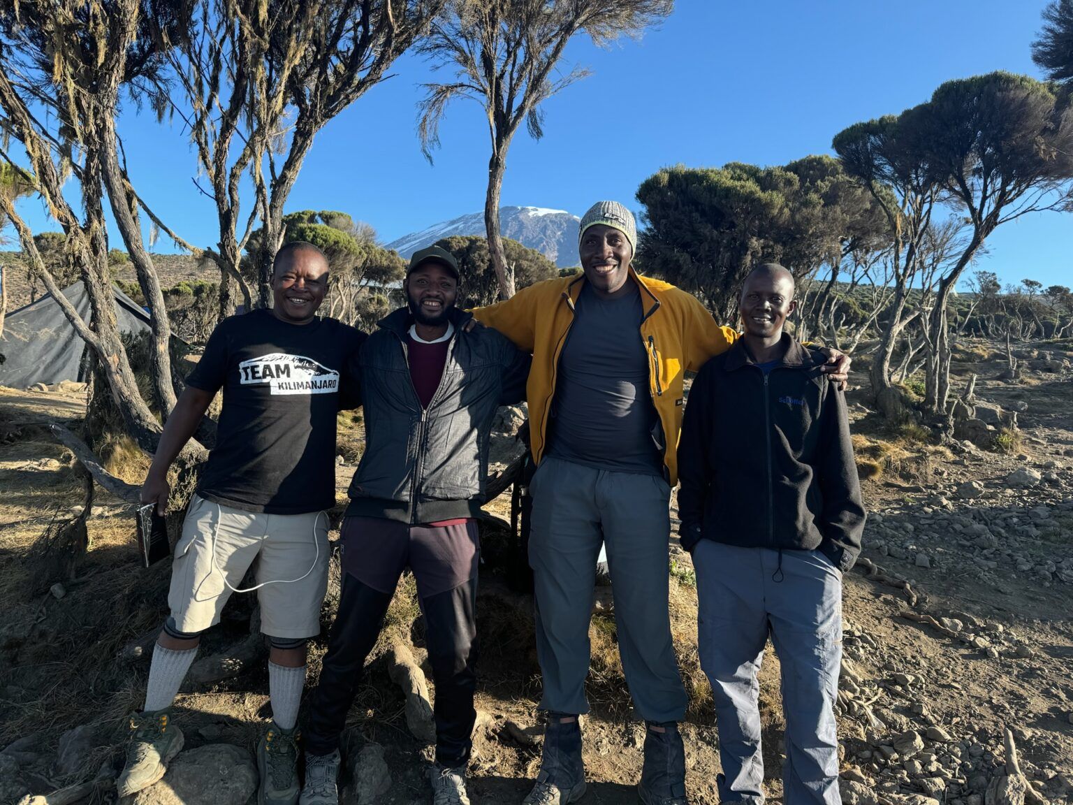 A group of men posing for a picture with trees in the background