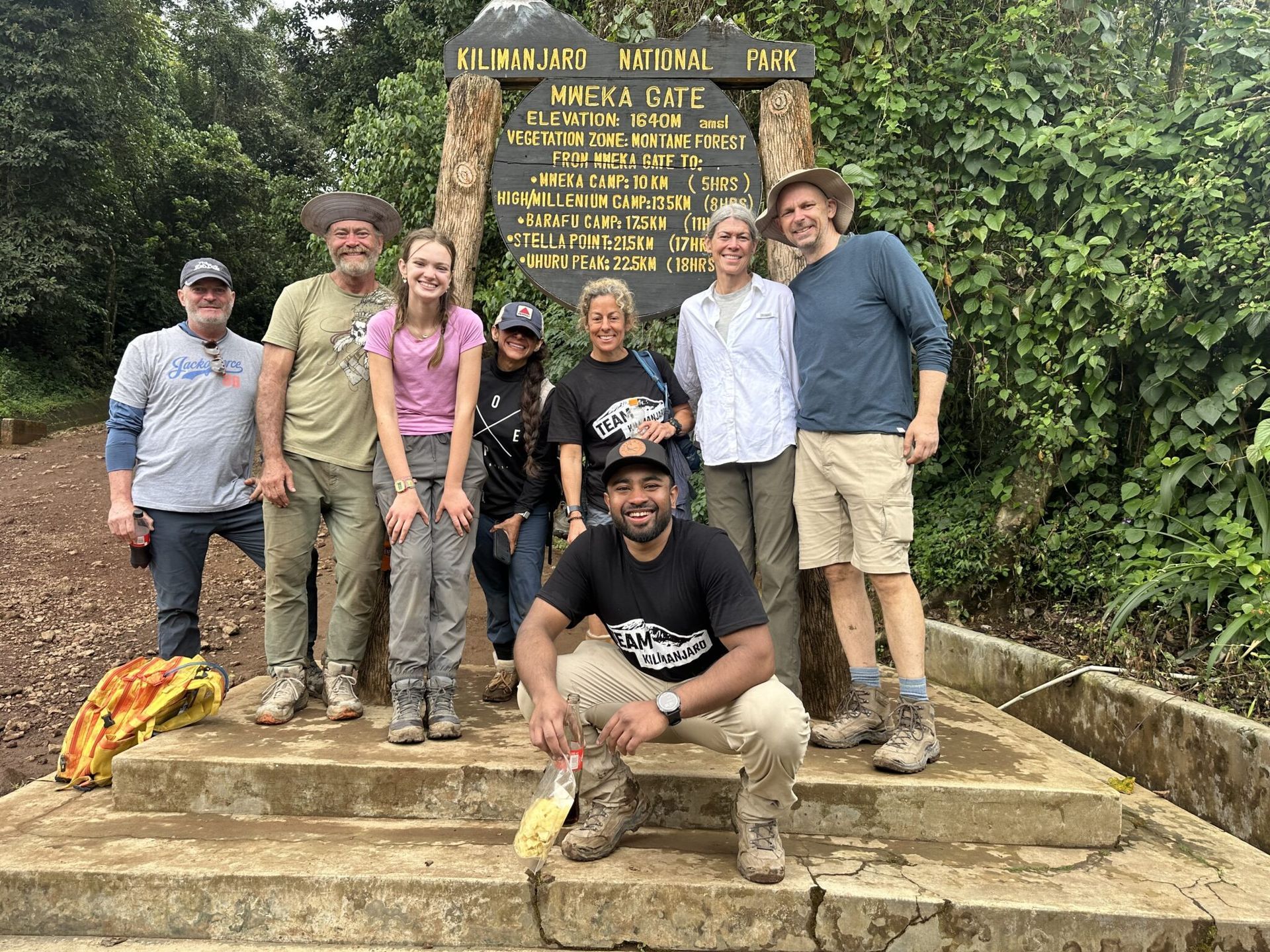 A group of people are posing for a picture in front of a sign.