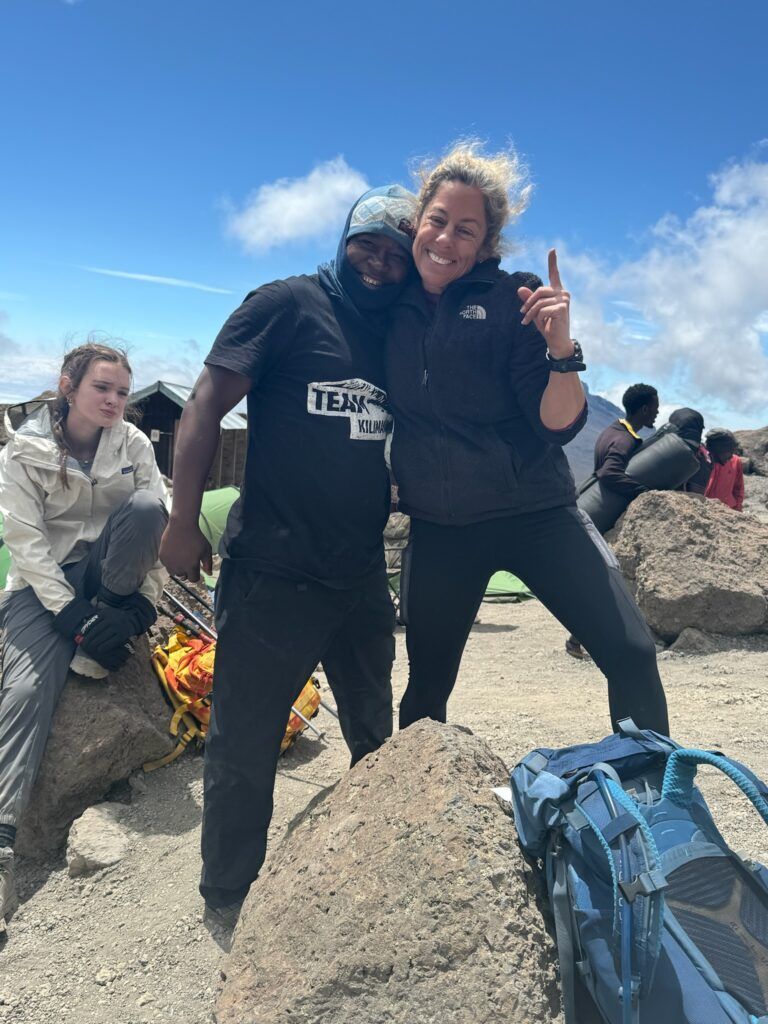 A man and a woman are posing for a picture on top of a rock.
