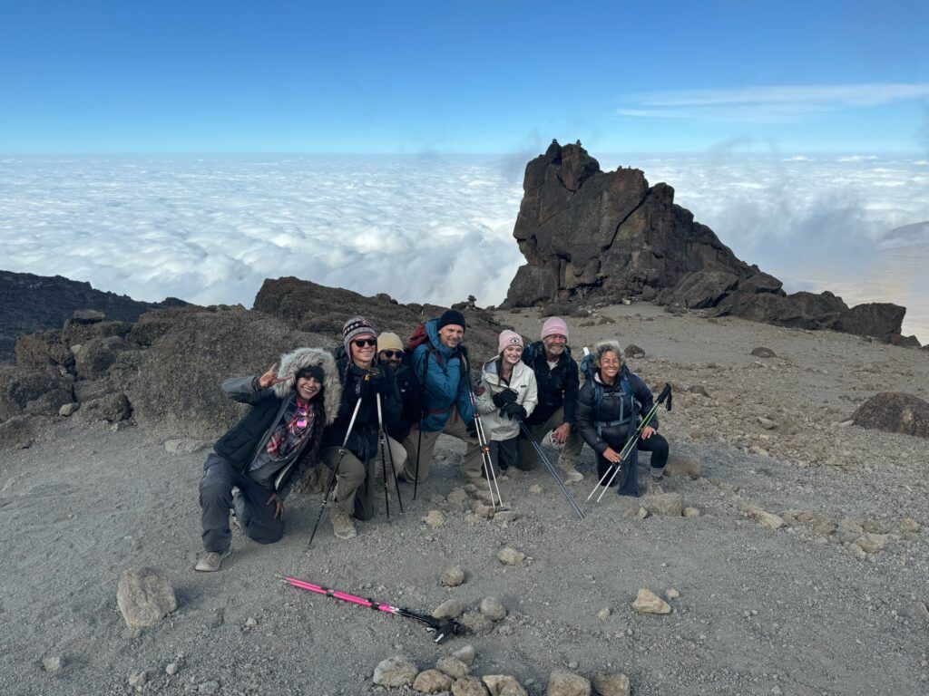 A group of people are posing for a picture on top of a mountain.