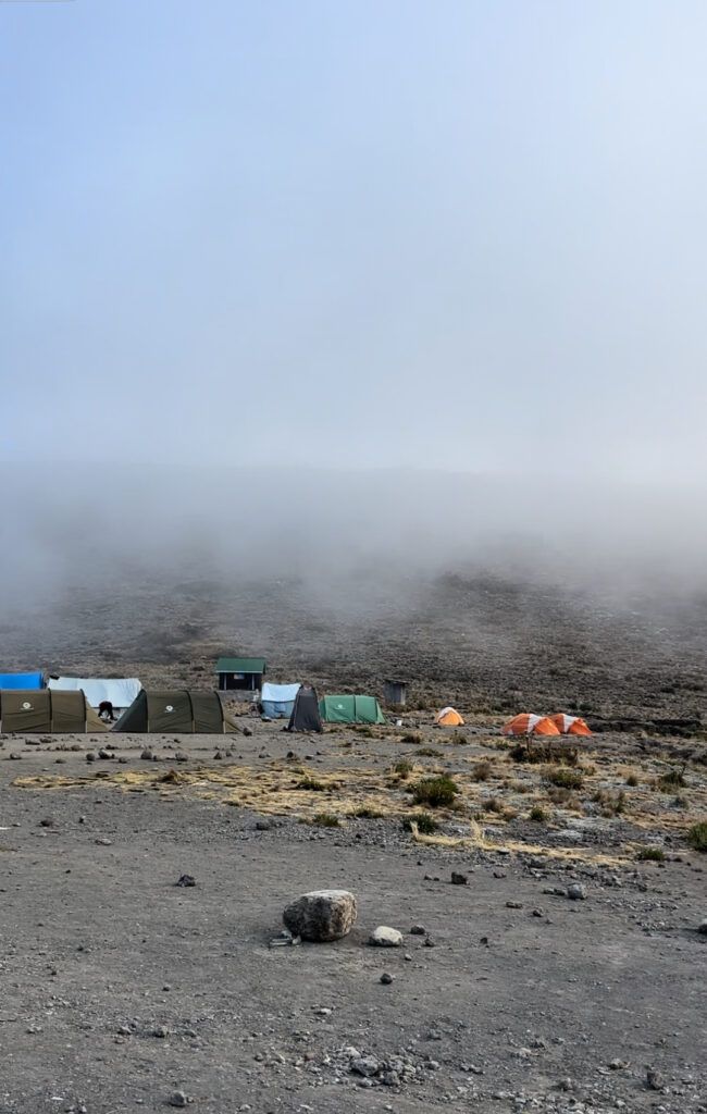 A group of tents are sitting in the middle of a desert.