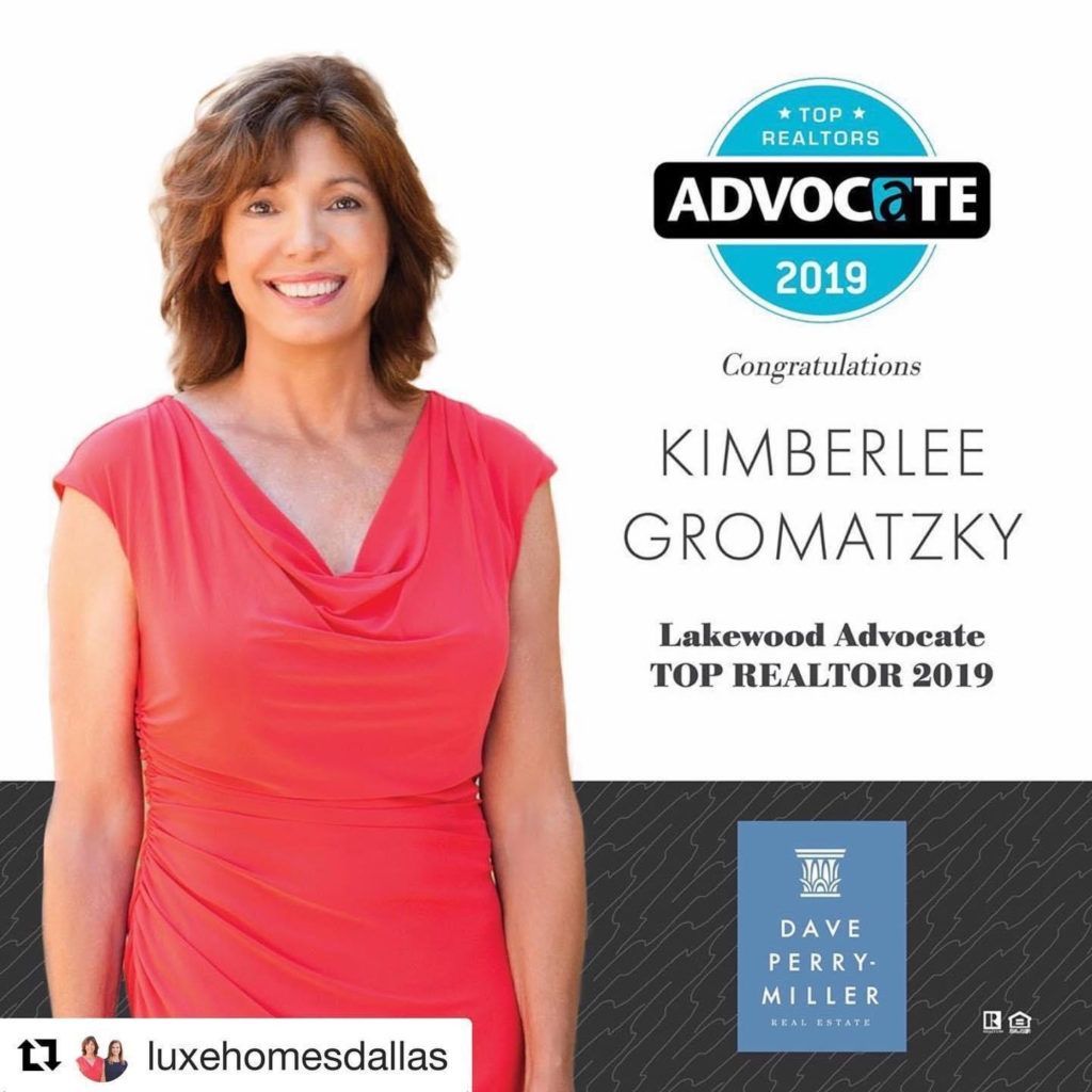 A woman in a red dress is standing in front of a sign that says advocate 2019
