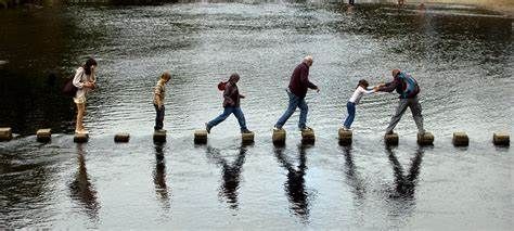 A group of people are walking across a river on blocks.