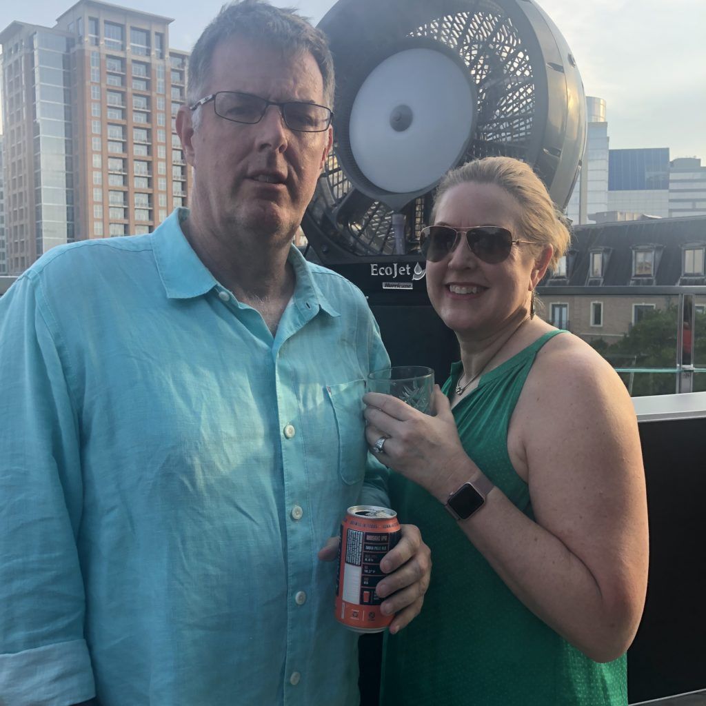 A man and a woman standing next to each other holding a can of soda