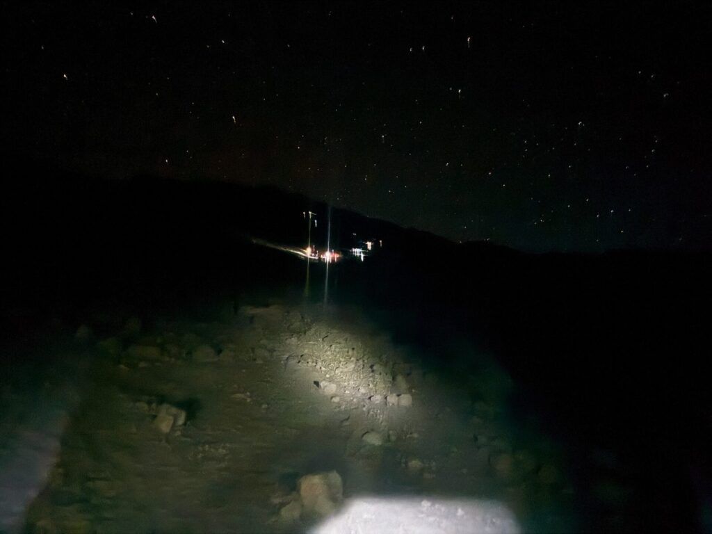 A person is standing in the dark with a flashlight.