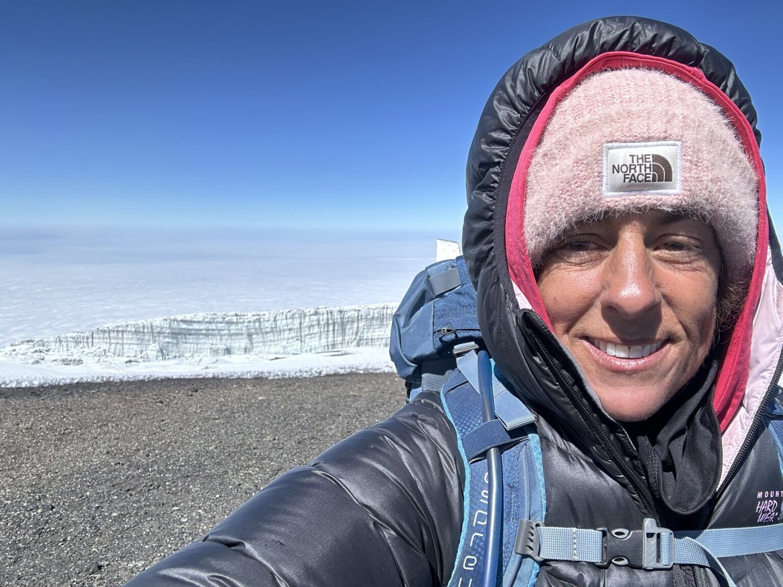 A woman wearing a north face hat and jacket is taking a selfie.