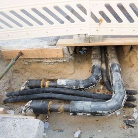 a bunch of pipes are laying in the dirt under a fence .