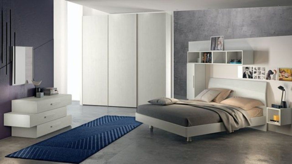 camera da letto con armadi bianchi e tappeto blu