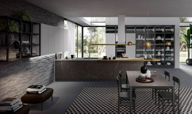 cucina con moduli effetto marmo scuro e lampade dorate