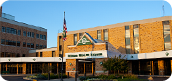 Building with a flagpole and the American flag waving, with 