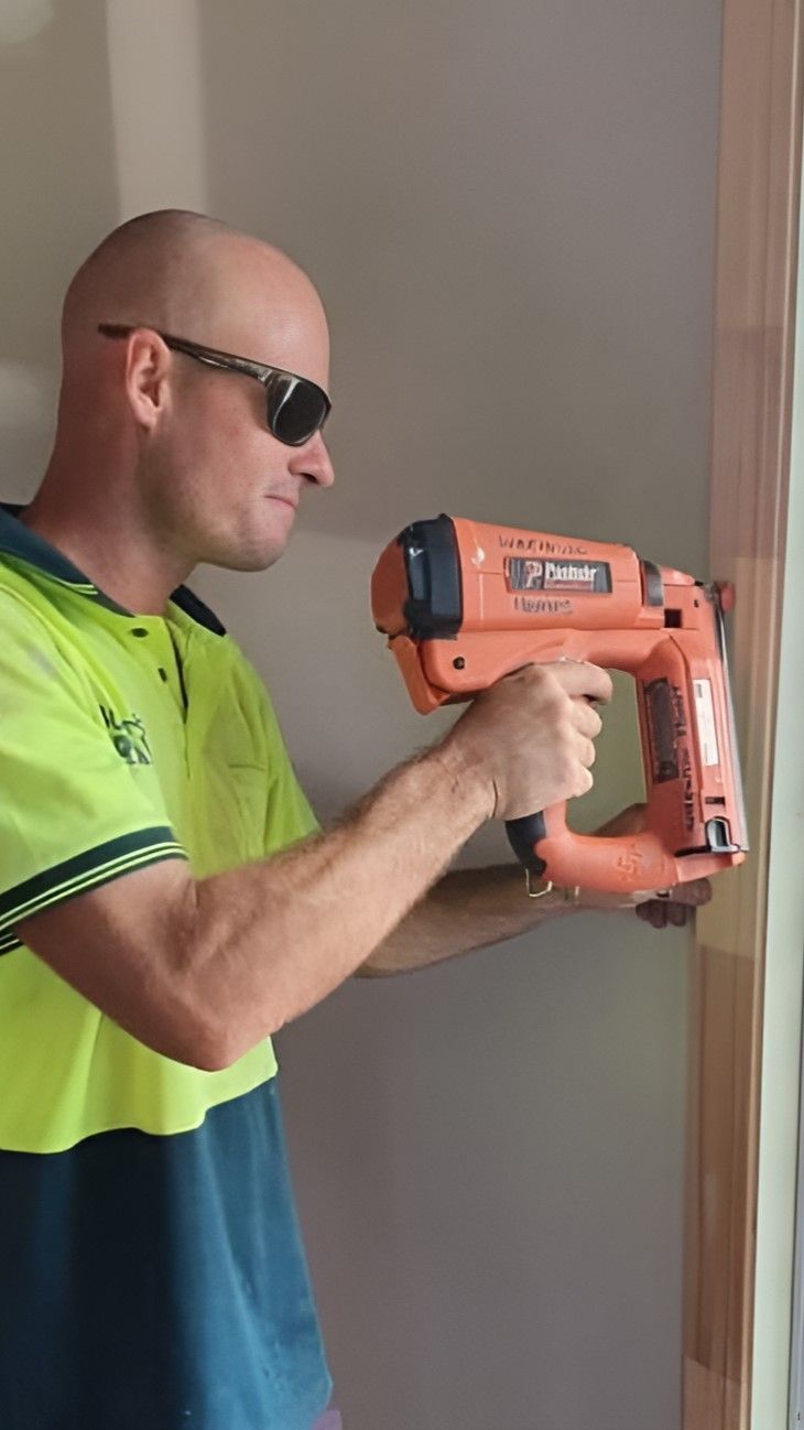 A Man Wearing Sunglasses is Operating a Nail Gun โ Wilkinson Homes in Annandale, QLD