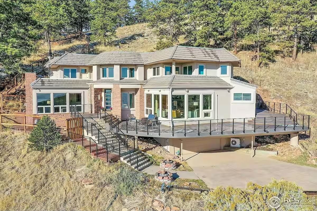 large Boulder home with windows and porch on the side of the mountain