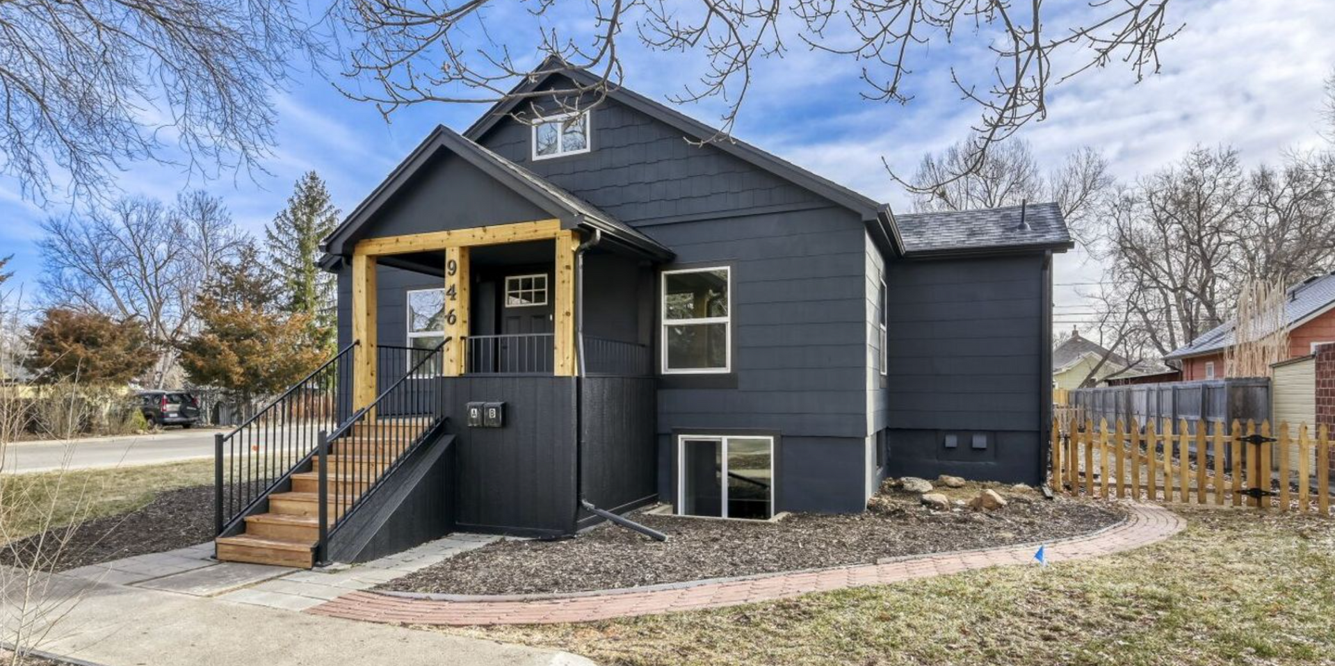 dark grey single-family home with wooden steps in Longmont