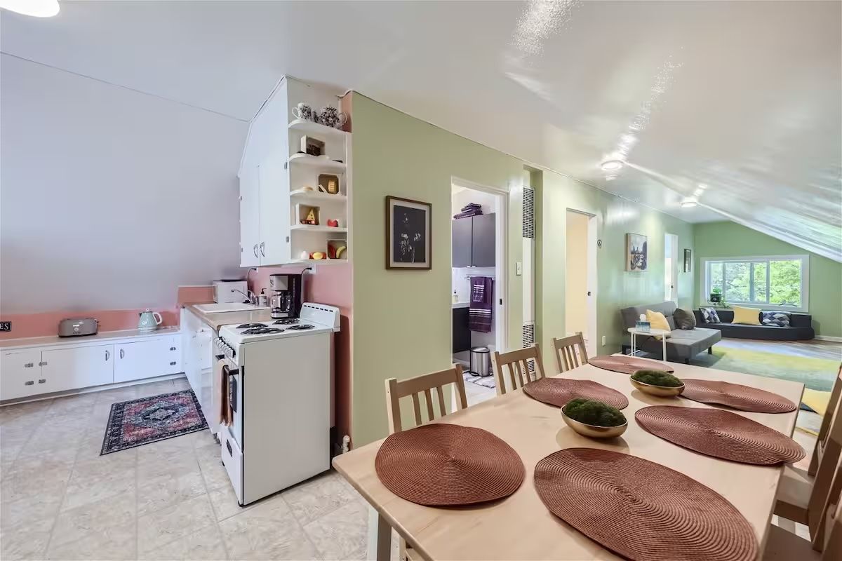 green walls and pink kitchen and big table 