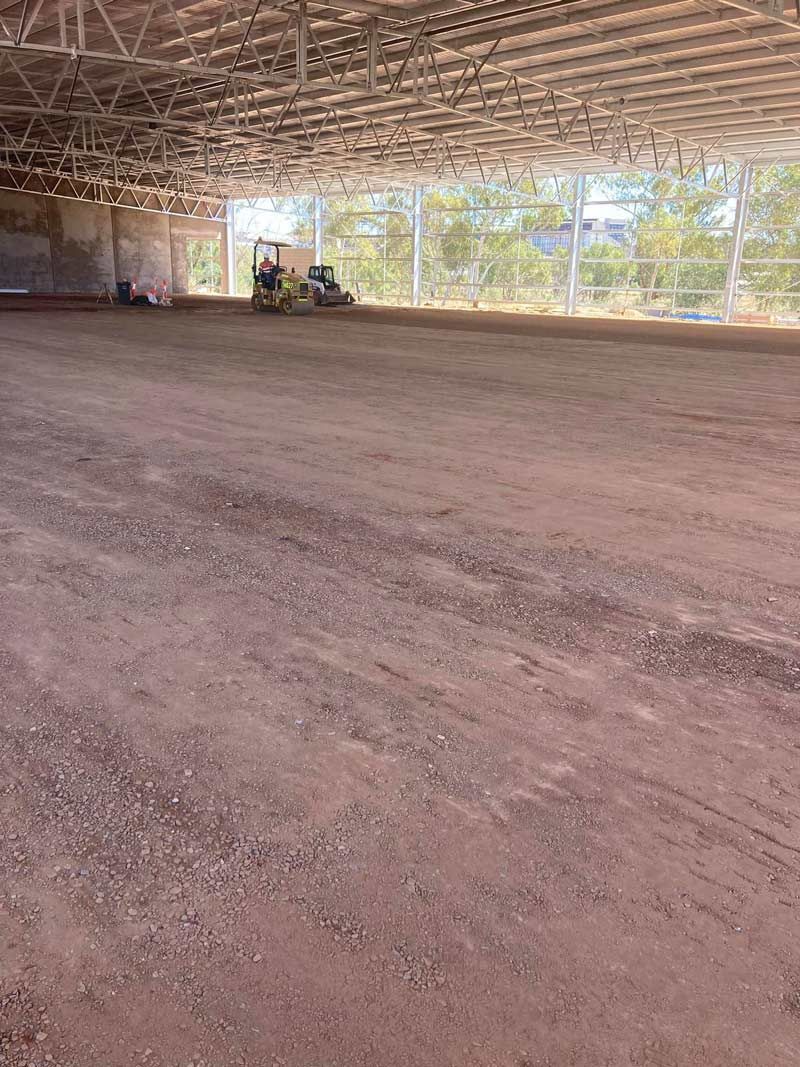 A Large Empty Warehouse With A Lot Of Dirt In It — NQES Industries in Ryan, QLD