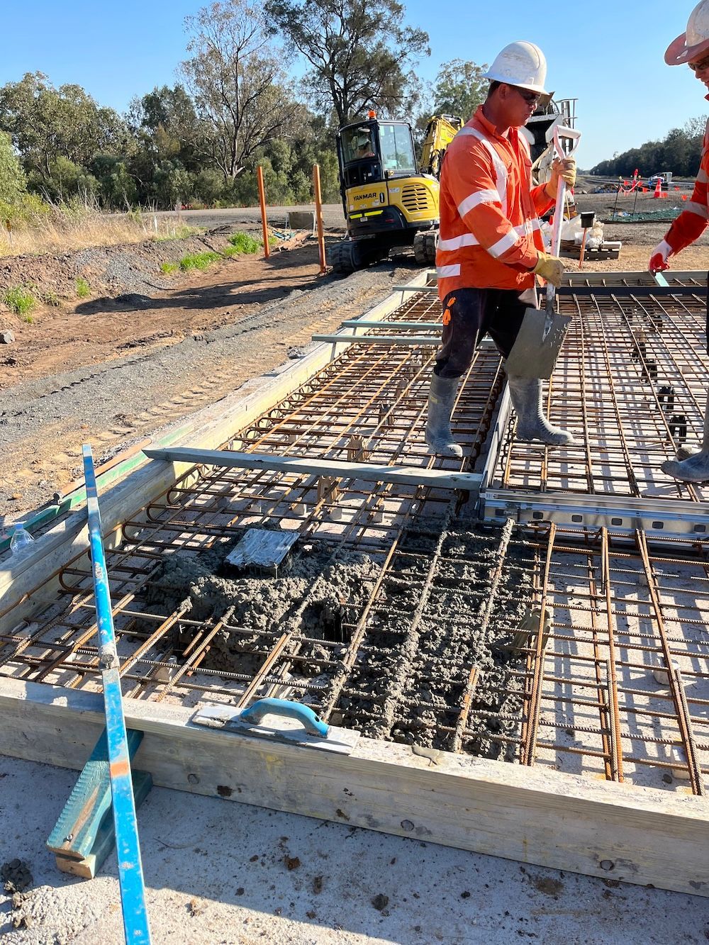 A group of construction workers are working on a concrete slab — NQES Industries in Ryan, QLD