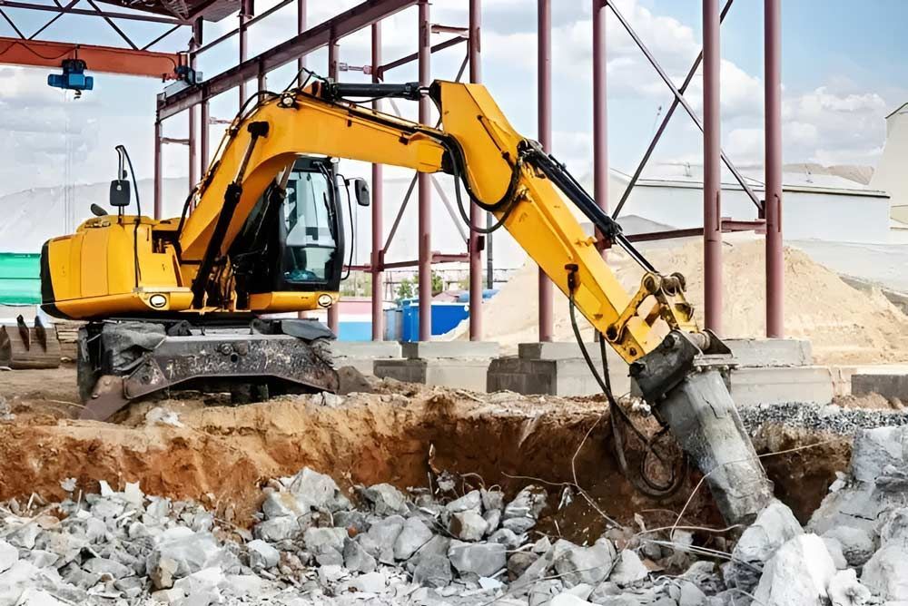 A Yellow Excavator Is Excavating A Hole In The Ground At A Construction Site — NQES Industries in Ryan, QLD