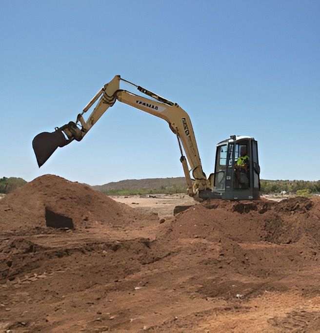 A Yellow Excavator Is Loading Dirt Into A Pile — NQES Industries in Ryan, QLD