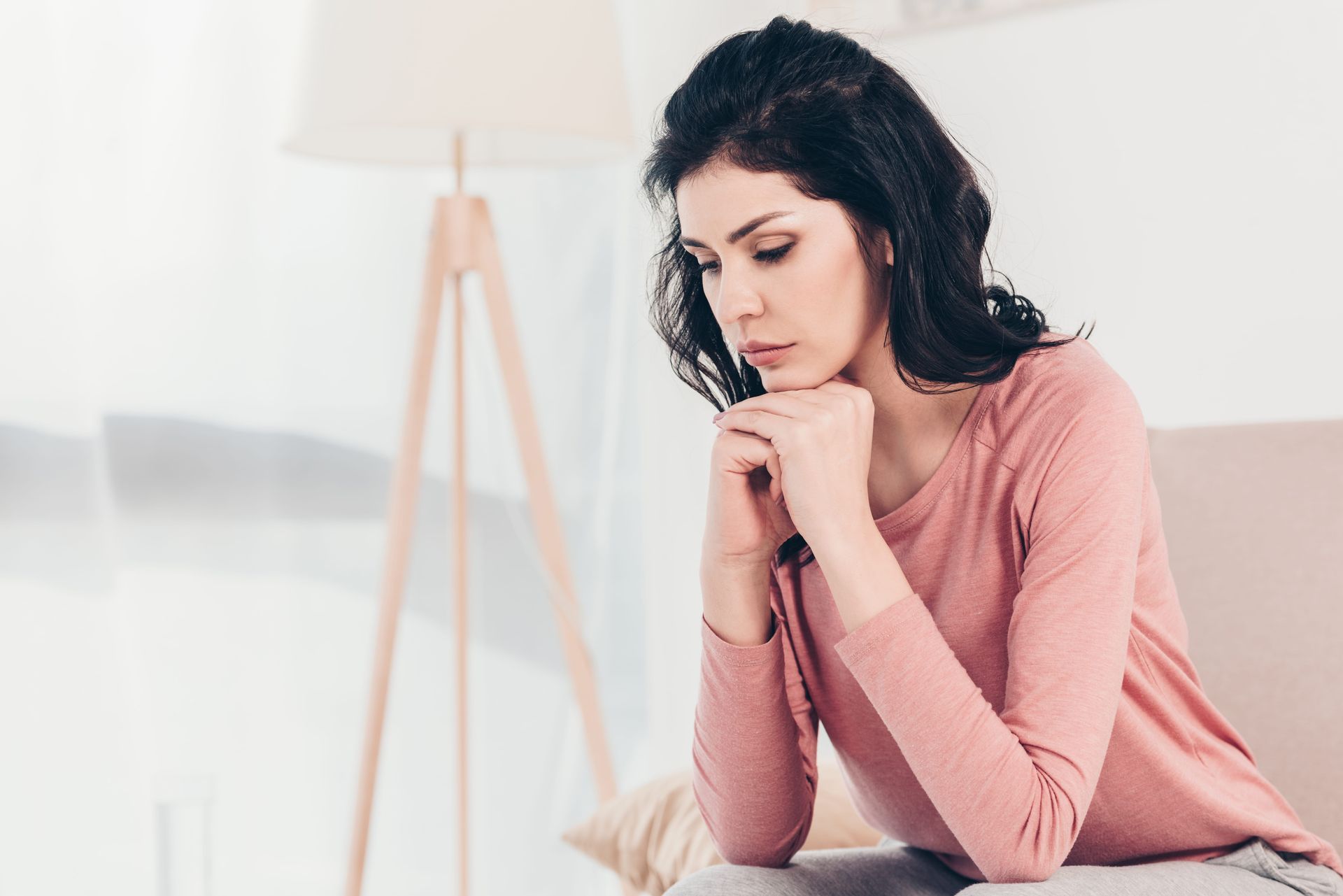 A woman sitting quietly looking down, low self-esteem therapy in Fairfax VA