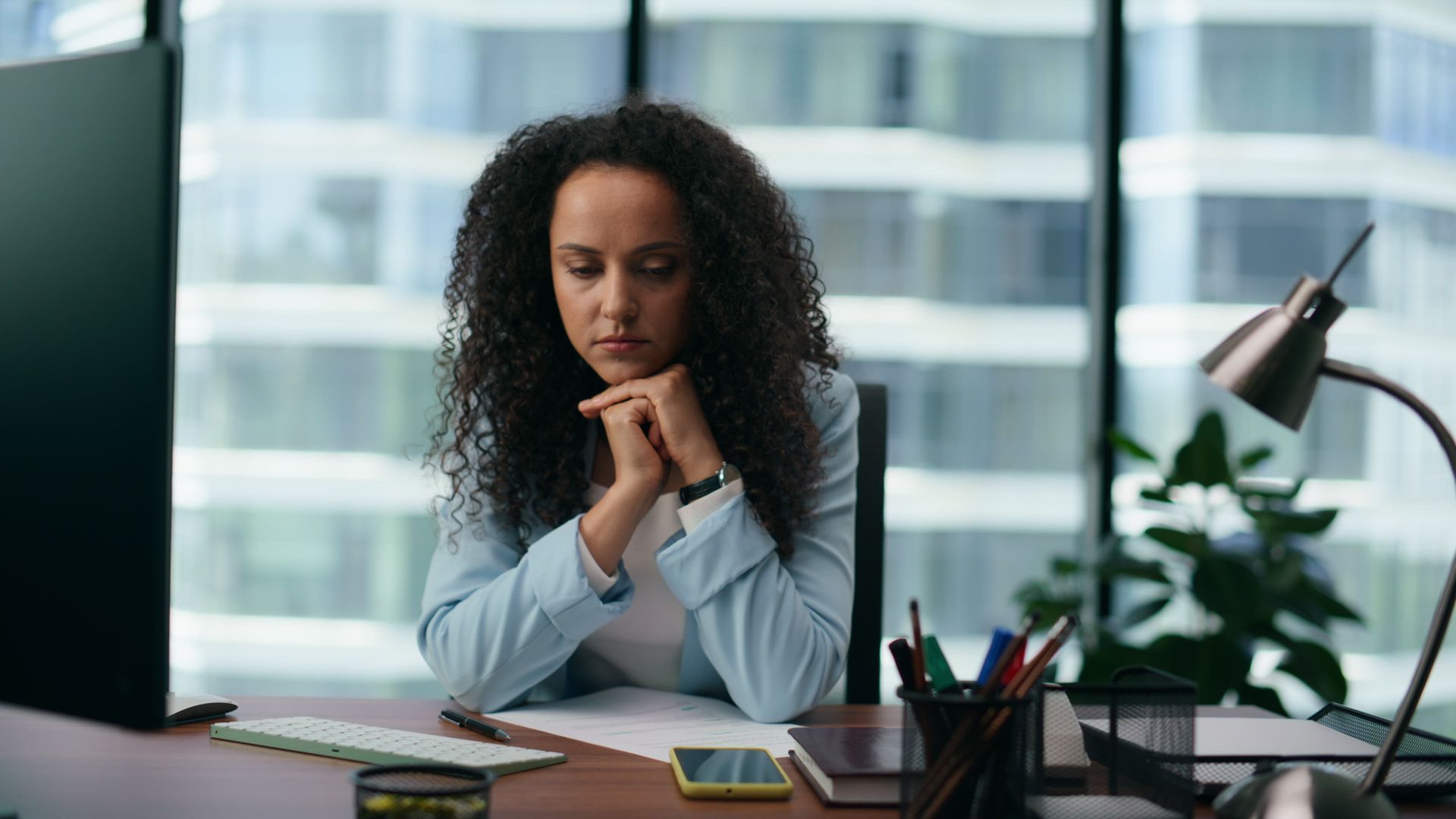 A woman sitting at her desk looking quietly exhausted, high-functioning depression therapy