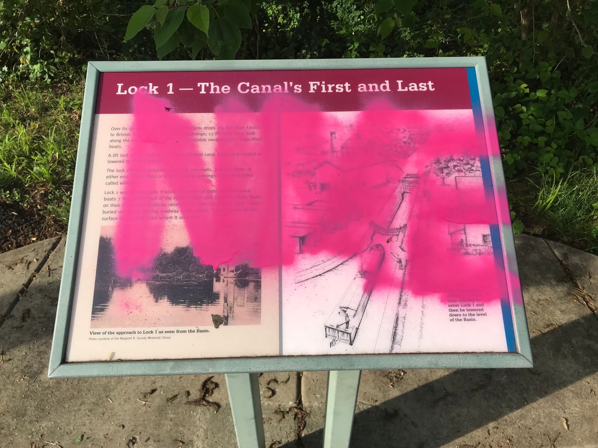 Sign for Lock 1 covered in bright pink graffiti.