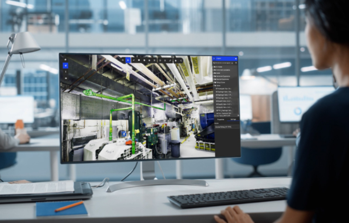 Person viewing a factory monitoring screen at a desk in a modern office