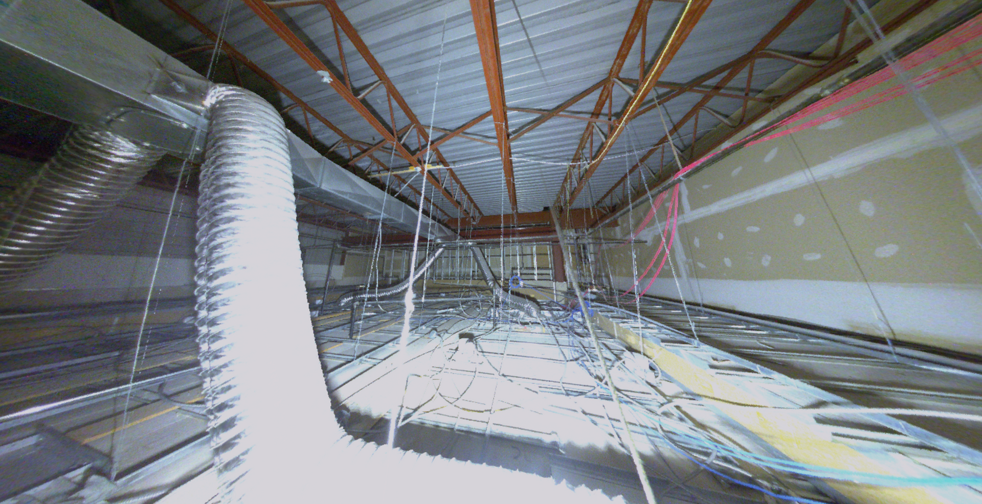 Interior of a building's unfinished ceiling. Exposed beams, ductwork, wires, and insulation.
