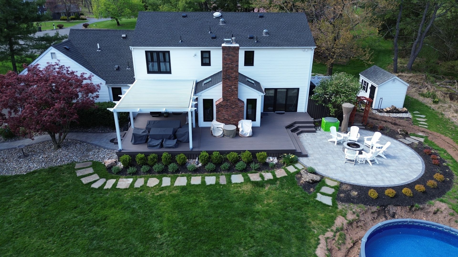 Custom deck with covered patio, fire pit, and landscaping built by New Dimensions Deck Contractors NJ