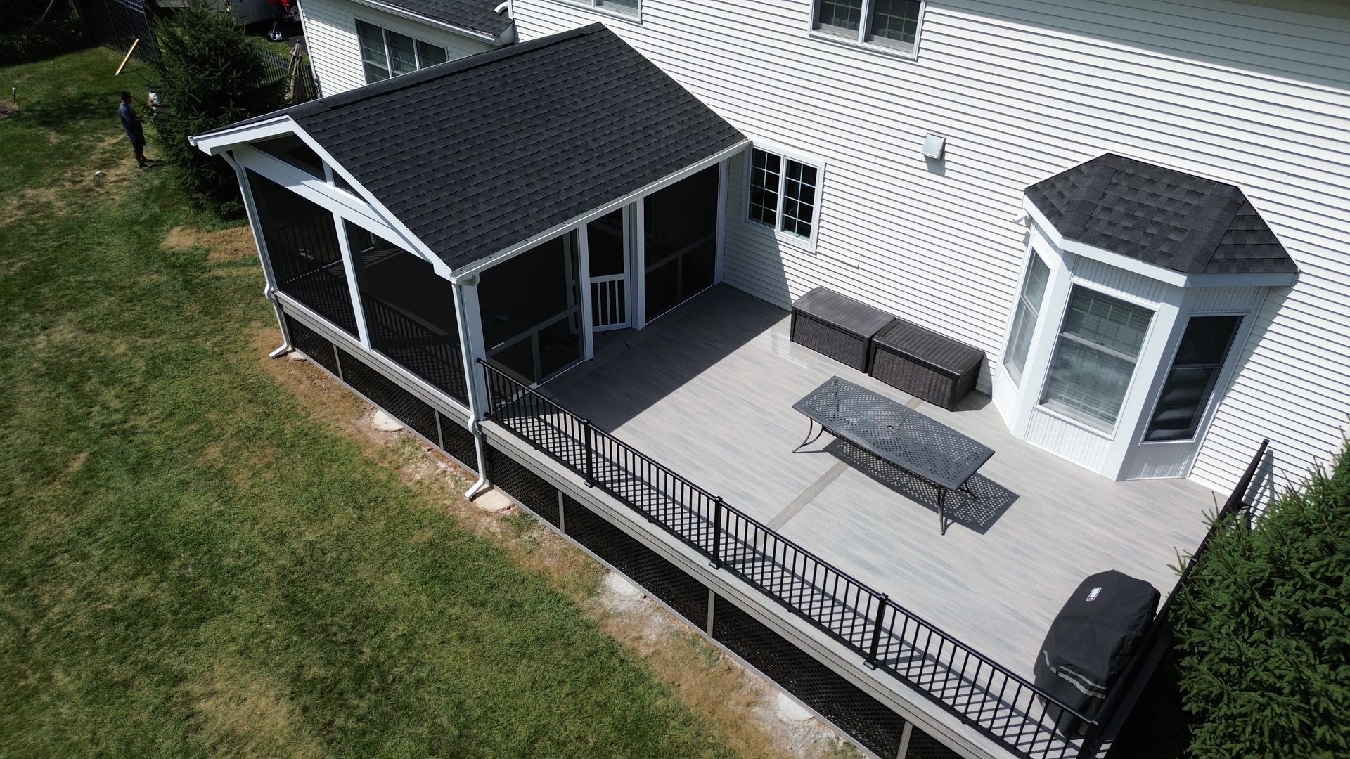 Composite deck with screened roof enclosure built by New Dimensions Deck Contractors in New Jersey