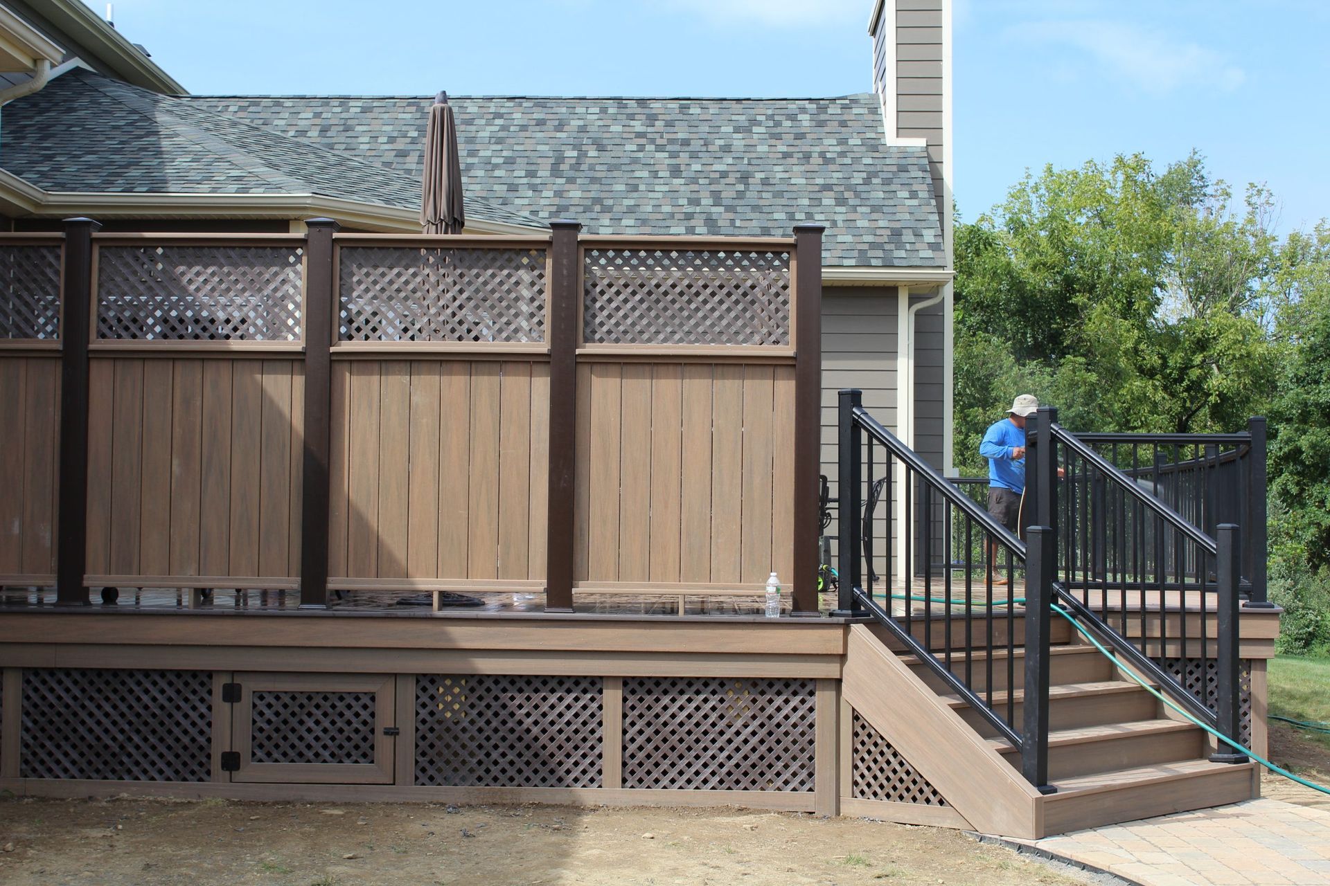 Privacy wall and black railing on composite deck with lattice skirting by New Dimensions NJ