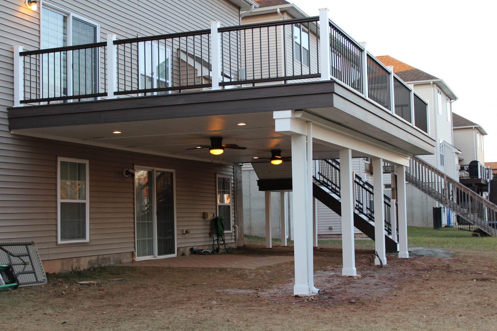 Contemporary deck with black railings surrounded by mature trees built by New Dimensions NJ