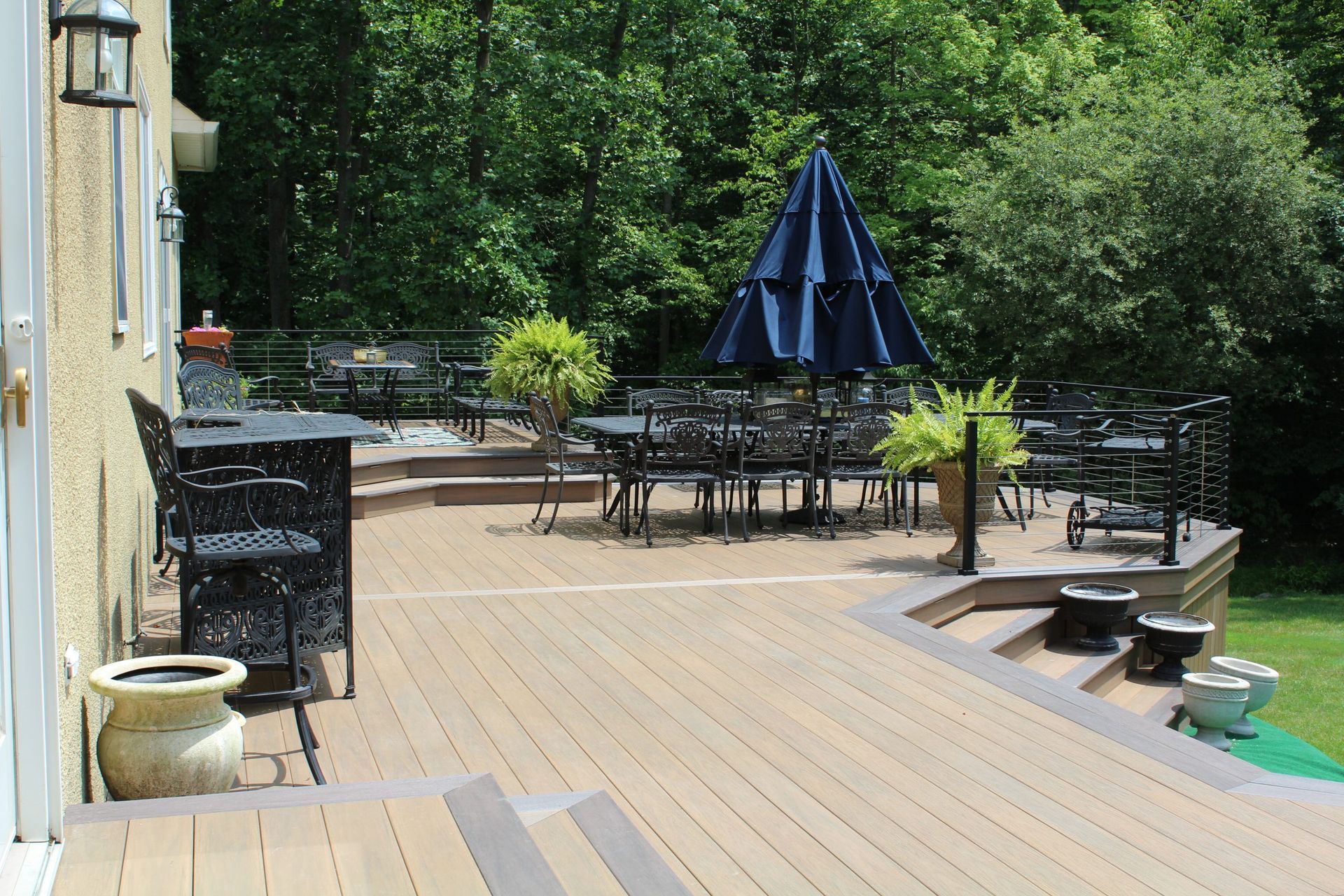 Large composite deck with built-in seating and white railings designed by NJ deck contractors