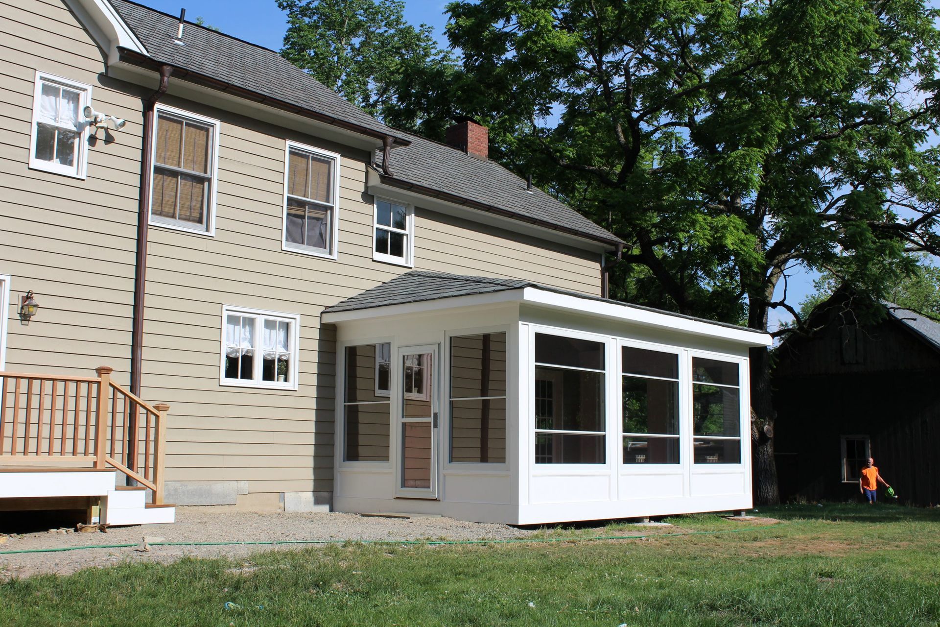 Screened-in porch attached to beige house.
