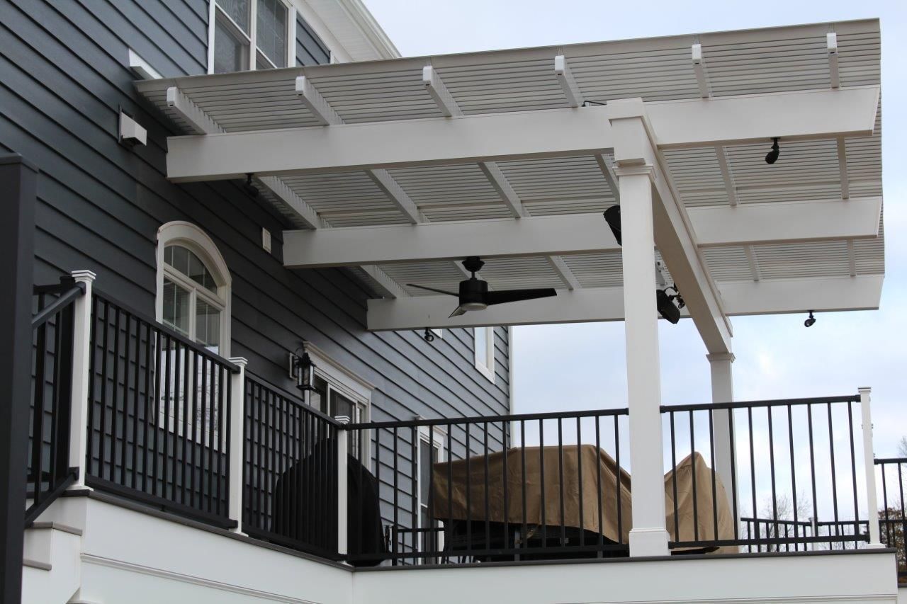 A deck with a pergola and a ceiling fan