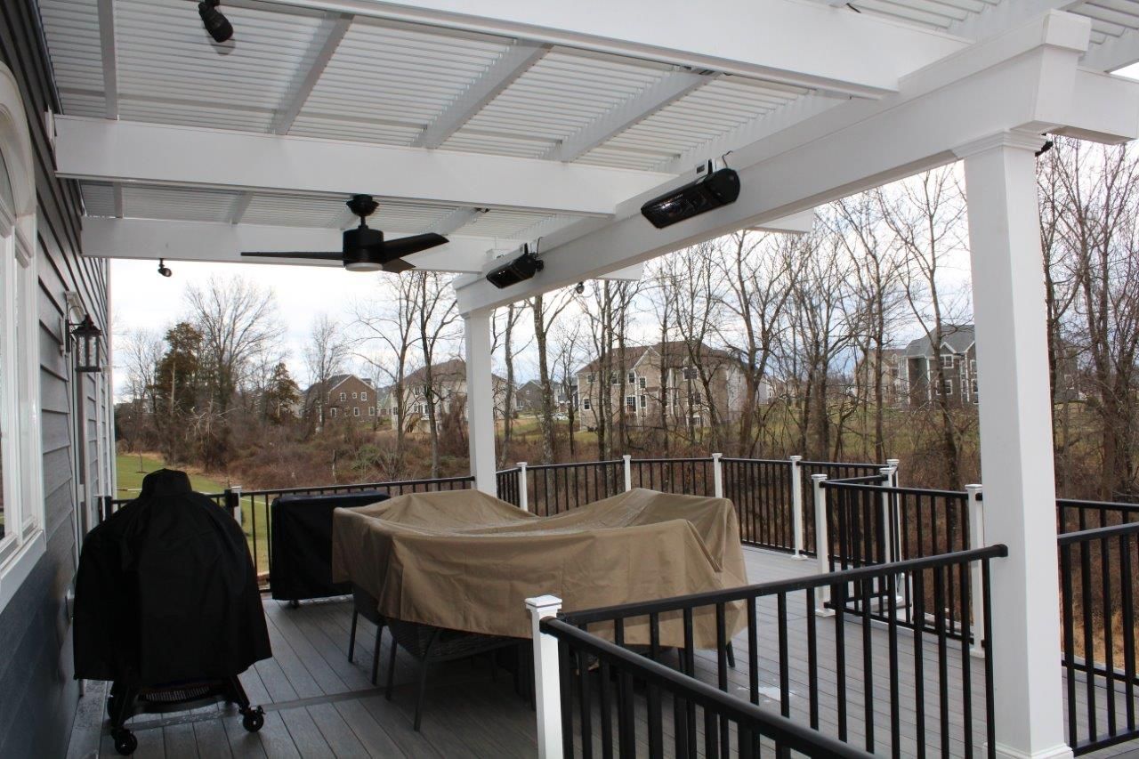 A porch with a table and chairs and a grill