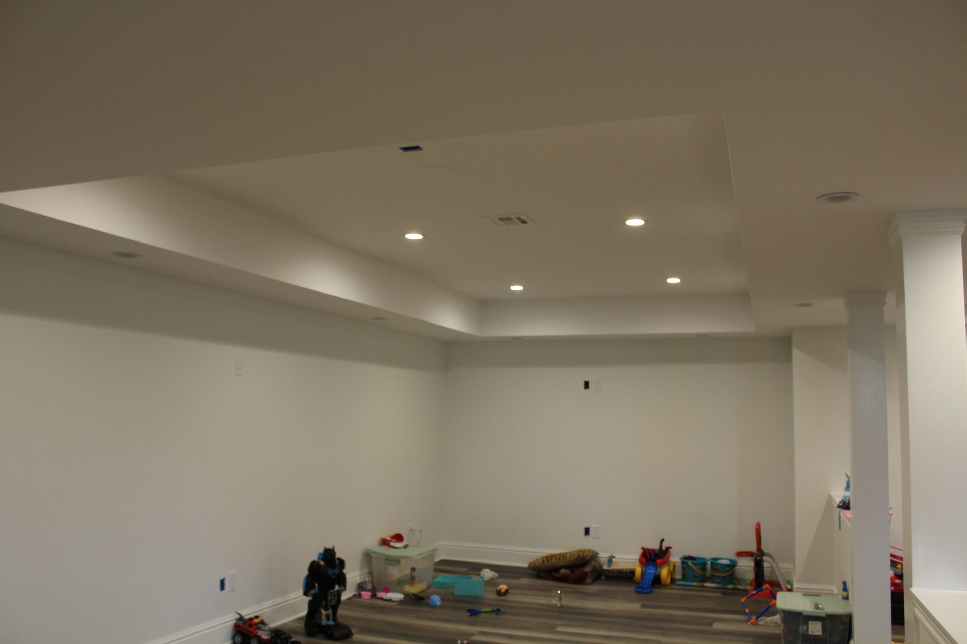 A basement with white walls and a ceiling that is being remodeled.