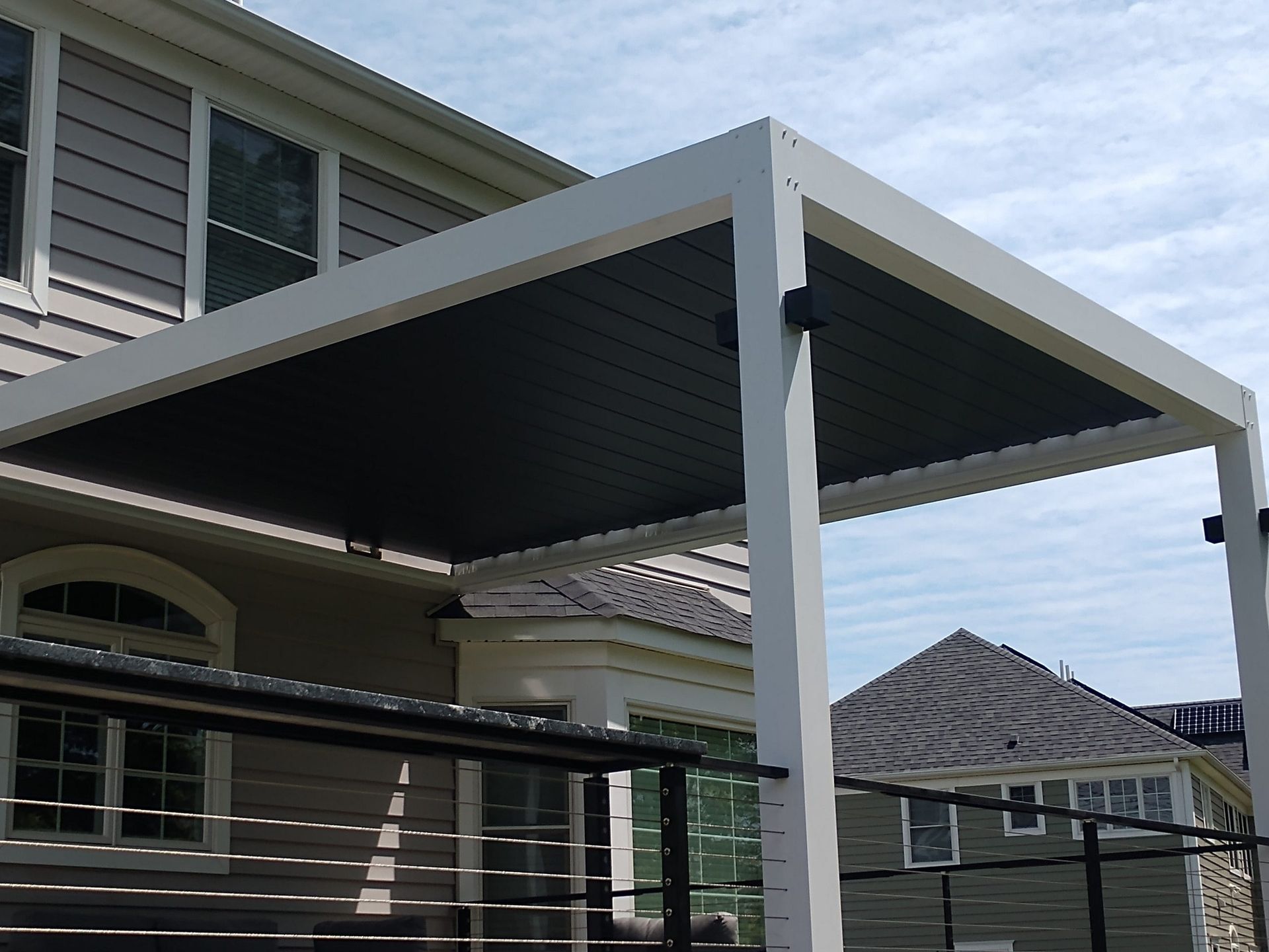 A house with a pergola on the side of it