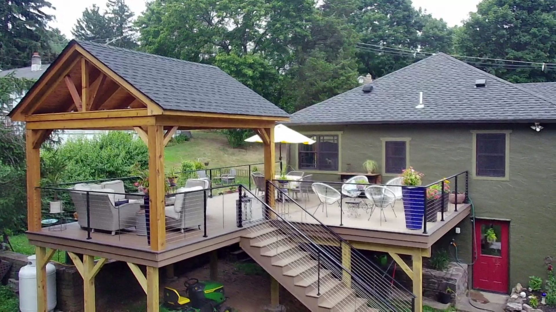 Outdoor raised deck with covered lounge area, modern railing, and multiple seating spaces.
