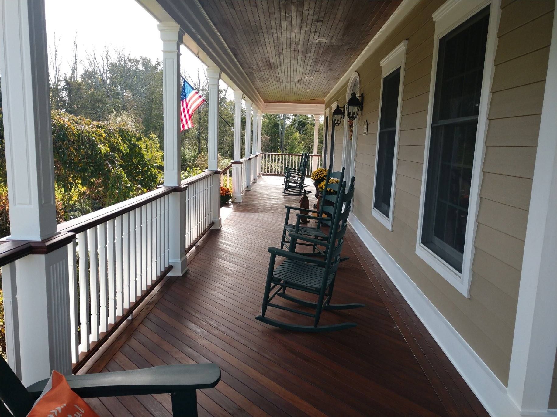 A porch with rocking chairs and an american flag